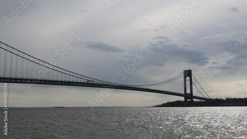traffic over the verrazzano bridge with water moving in river nyc new york city harbor (cloudy gray overcast day) scenic suspension cables between brooklyn and staten island cars trucks buses driving
