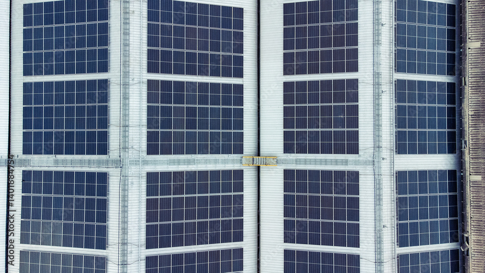 multiple solar panels installed on the rooftop of a building. The solar panels are arranged in neat rows and columns, with clear separations between each panel.