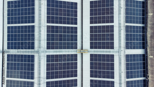 Obraz na płótnie multiple solar panels installed on the rooftop of a building. The solar panels are arranged in neat rows and columns, with clear separations between each panel. w salonie