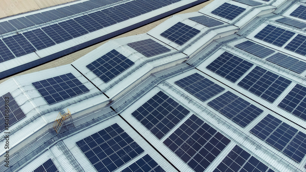 multiple solar panels installed on the rooftop of a building. The solar panels are arranged in neat rows and columns, with clear separations between each panel. 