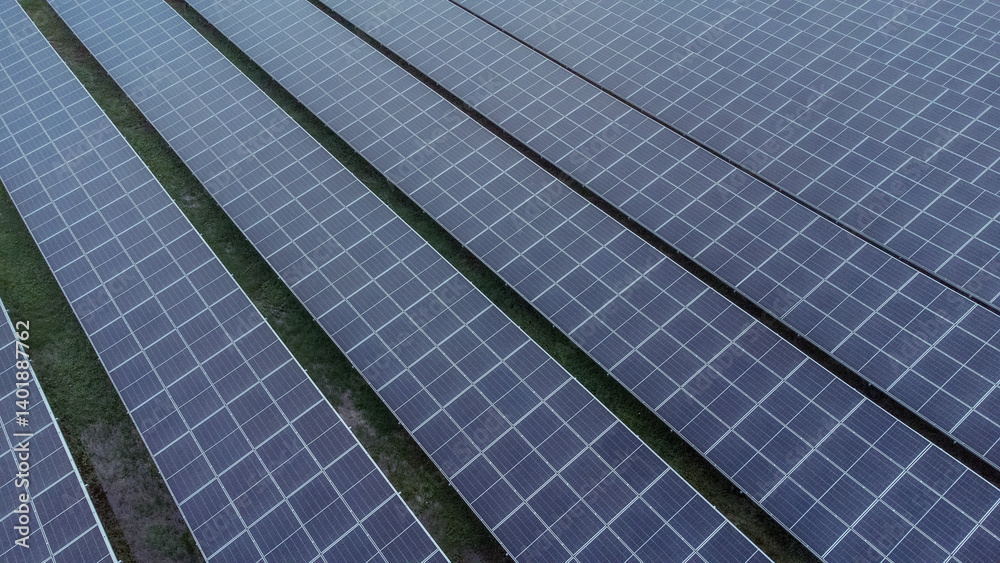 multiple solar panels installed on the rooftop of a building. The solar panels are arranged in neat rows and columns, with clear separations between each panel. multiple solar panels installed on the rooftop of a building. The solar panels are arranged in neat rows and columns, with clear separations between each panel.