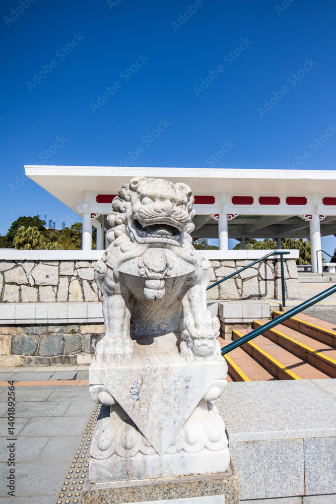 Stone Chinese Guardian Lion at Traditional Entrance on a Clear Day