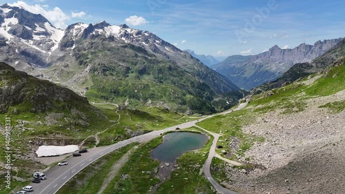 Flight over top of mountain pass Susten Pass with serpentine road towards lake Steinsee and mountain panorama in the Swiss Alps, Switzerland