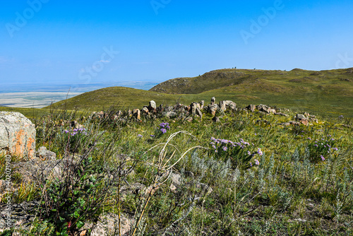 Khakassia. Old stone wall. Mountain landscape with blue sky
