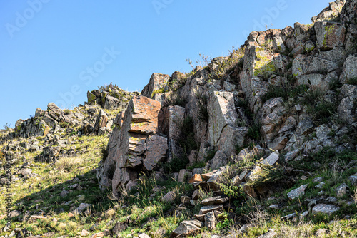 Khakassia. Old stone wall. Mountain landscape with blue sky