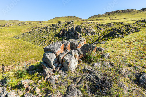 Khakassia. Old stone wall. Mountain landscape with blue sky