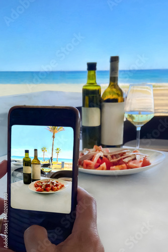 Tourist taking mobile photo of tuna salad by the sea