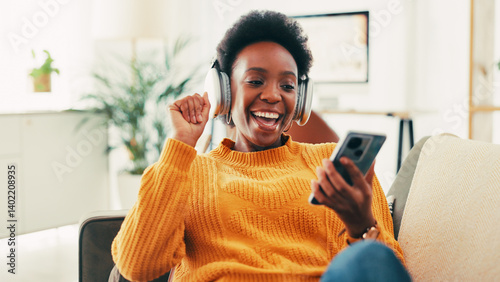 Photos Black woman, phone and headphones on sofa in home, music and relax with sound in living room