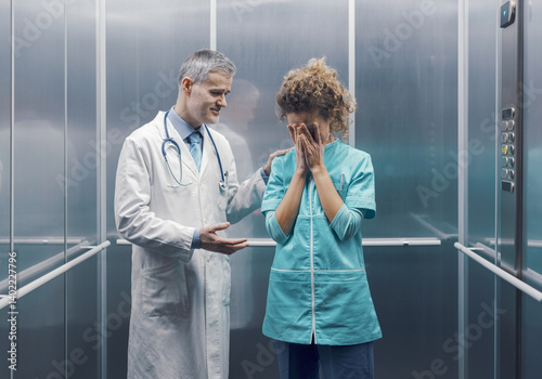 Doctor supporting a colleague in the elevator