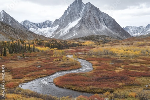 A Winding River Flows Through Autumnal Tundra Below Majestic Snow-Capped Mountains.