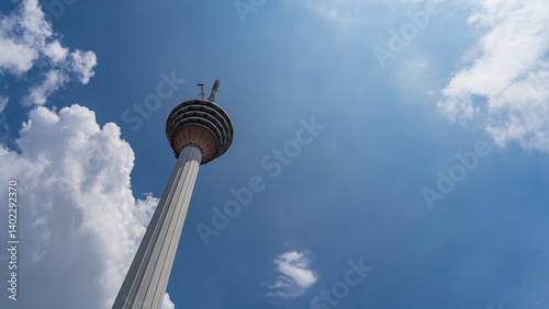 Photography A television tower on a background of blue sky and clouds