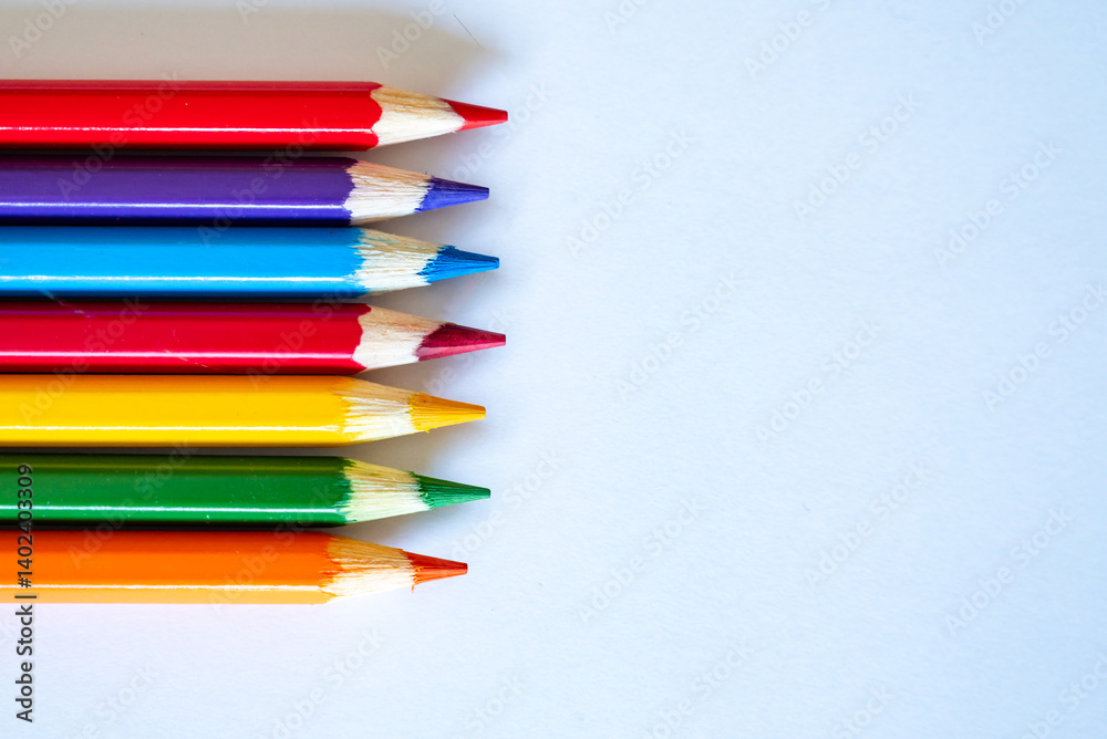 colored pencils laud out on a blank white sheet of paper colored pencils laud out on a blank white sheet of paper