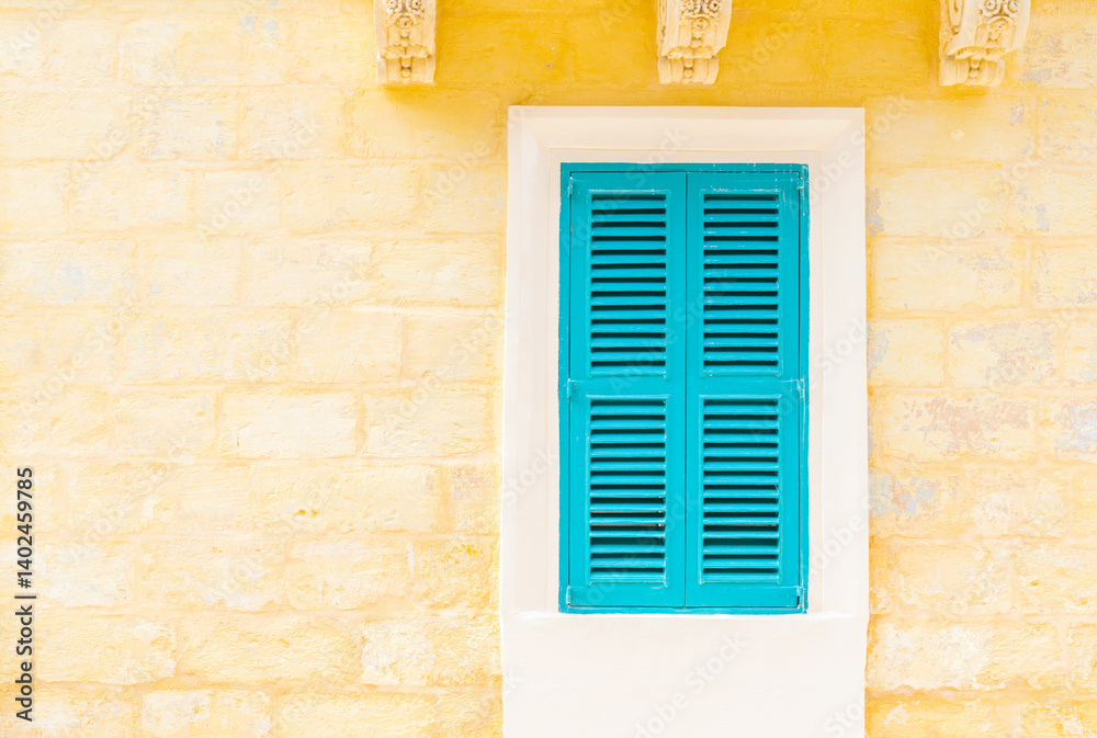 Stone brick wall with a closed turquoise wooden window with shutters
