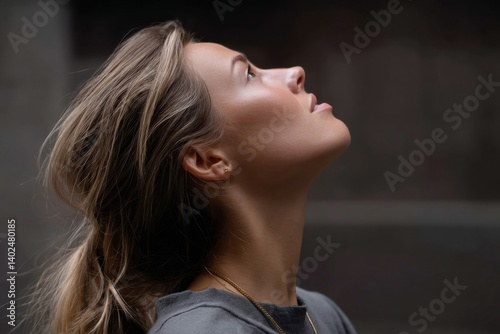 Blonde Woman Gazing Upward: Profile of a woman looking up, light catching her features, exuding a sense of wonder and contemplation.