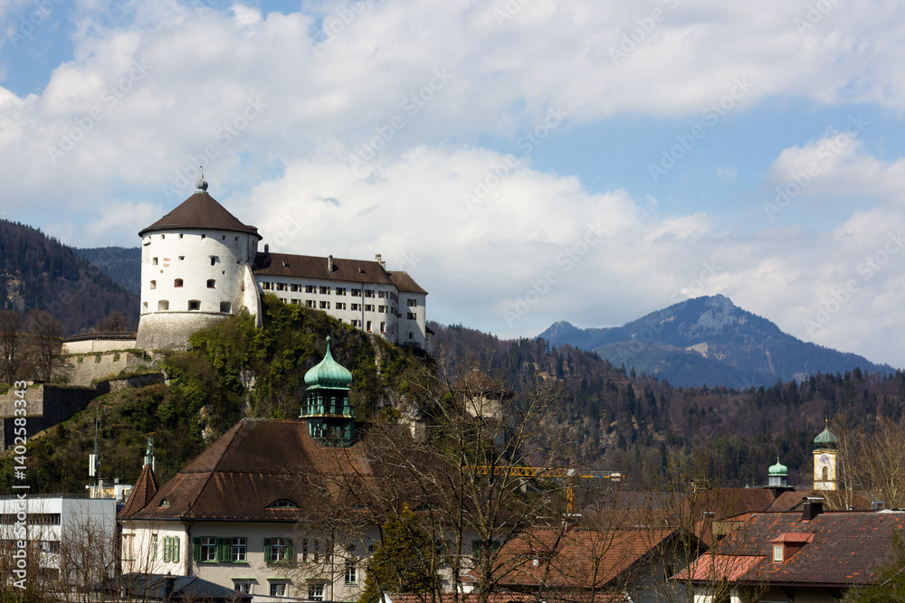 Majestic snow-capped mountains tower over a charming Austrian town nestled below Majestic snow-capped mountains tower over a charming Austrian town nestled below