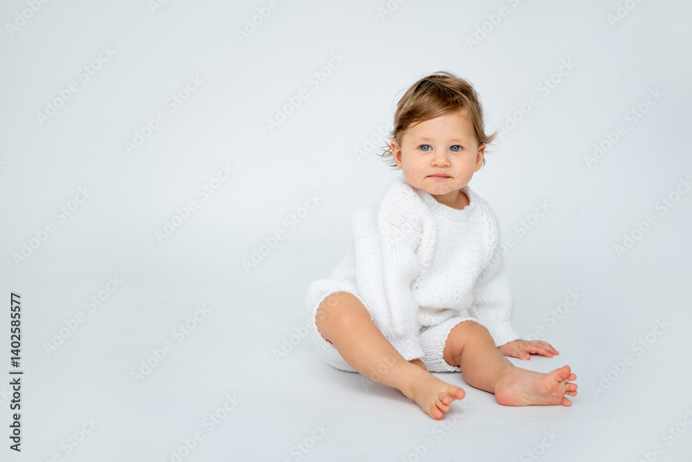 A baby boy on a white isolated background with a place for text is sitting in white knitted clothes. A small happy child in a winter sweater , space for text A baby boy on a white isolated background with a place for text is sitting in white knitted clothes. A small happy child in a winter sweater , space for text