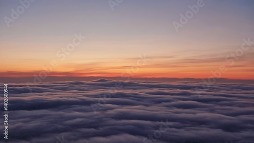 Obraz na płótnie Aerial view of clouds at sunset from an airplane. Silhouette of clouds against orange sky w salonie
