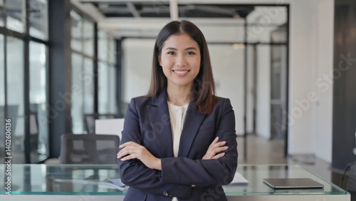 Obraz na płótnie A young businesswoman with a confident smile, standing in an office setting. w salonie