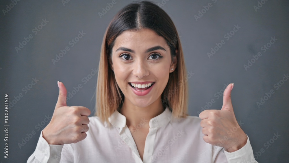 Woman in business attire gives thumbs up, conveying positivity, confidence, and trustworthiness.