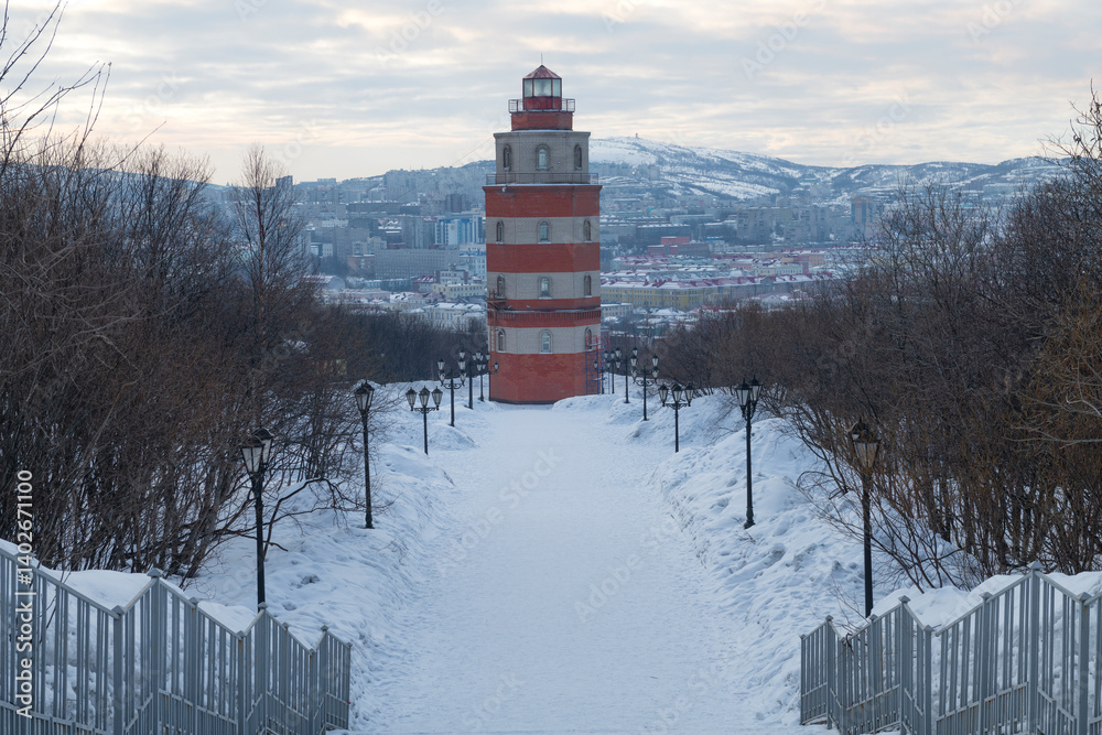 A lighthouse chapel in memory of sailors who died in peacetime against the backdrop of a city landscape on a cloudy March day. Murmansk