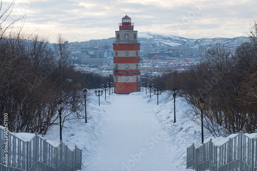 Obraz na płótnie A lighthouse chapel in memory of sailors who died in peacetime against the backdrop of a city landscape on a cloudy March day. Murmansk w salonie