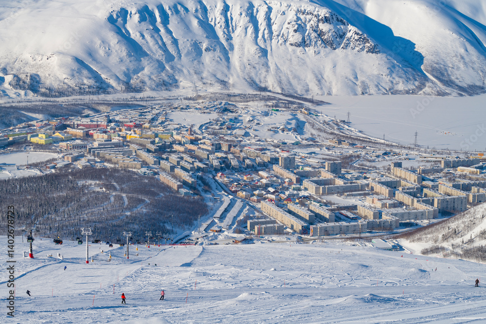 View from Mount Aikuayvenchorr to the city of Kirovsk on a sunny March day. Murmansk region