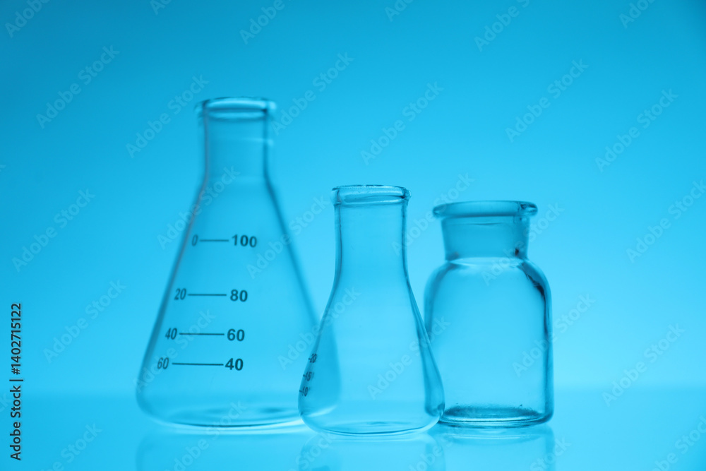 Empty flasks on light blue background. Laboratory equipment Empty flasks on light blue background. Laboratory equipment