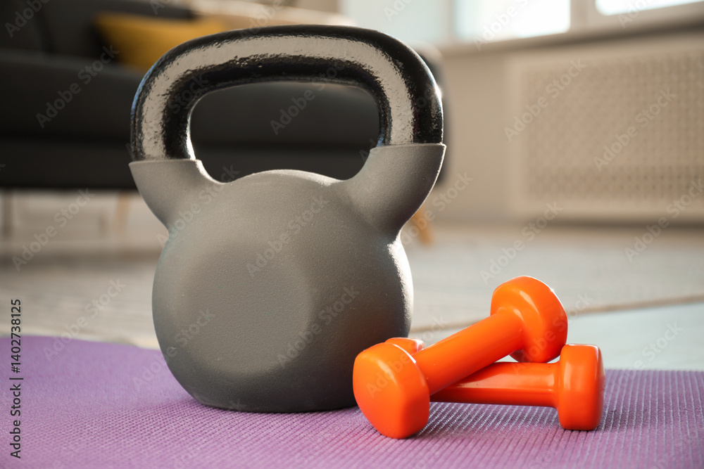 Fototapeta premium Kettlebell and dumbbells on fitness mat at home