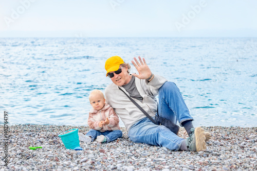 Obraz na płótnie A man and his baby have a delightful day at the beach, creating lasting memories by the beautiful sea w salonie