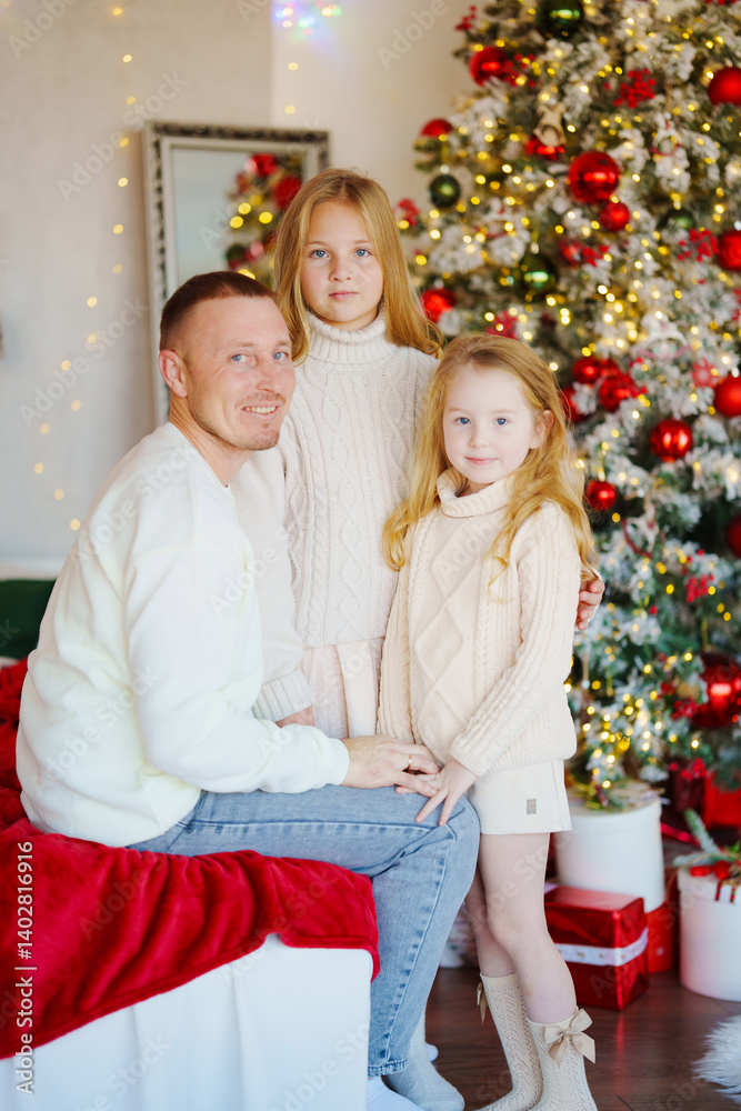 Father and daughters at the Christmas tree.