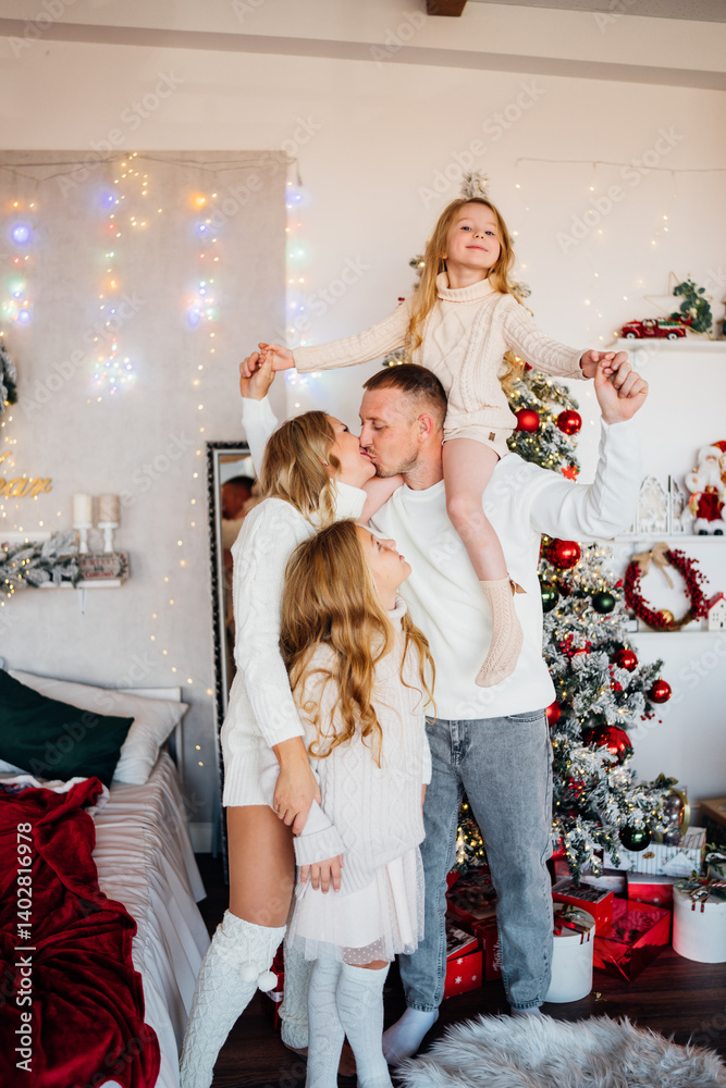 A beautiful and happy family at the Christmas tree at home