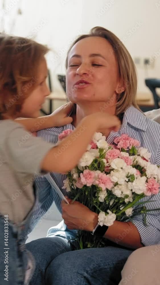 Three children celebrate Mother's Day by giving their mom flowers and a greeting card at home. She smiles, surrounded by love and joy. Concept of motherhood and family connection. Mid-range shot Three children celebrate Mother's Day by giving their mom flowers and a greeting card at home. She smiles, surrounded by love and joy. Concept of motherhood and family connection. Mid-range shot