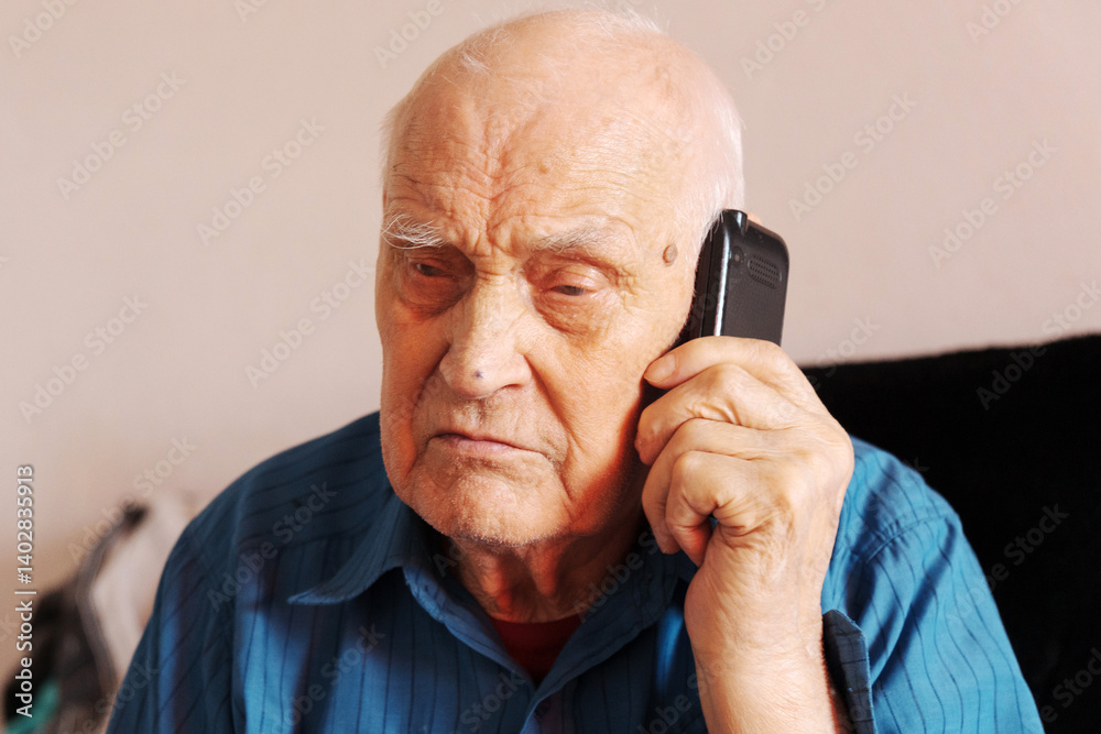 An elderly man in a blue shirt animatedly talks on the phone, his expressive face revealing deep emotions and connection An elderly man in a blue shirt animatedly talks on the phone, his expressive face revealing deep emotions and connection
