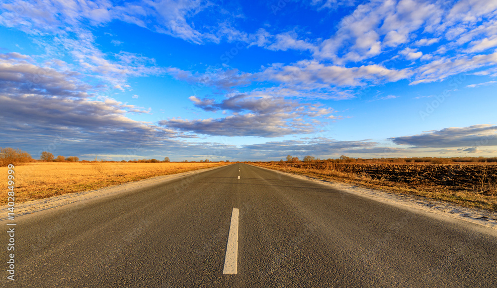 Fototapeta premium A long, empty road with a clear blue sky above