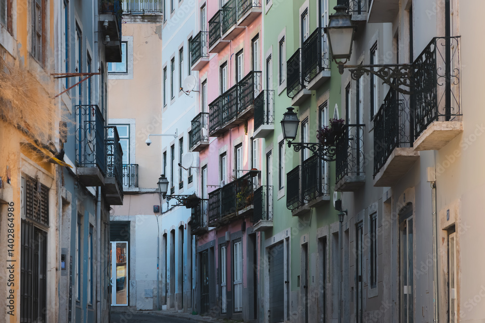 Fototapeta premium A narrow backstreet in Bairro Alto, Lisbon, is lined with pastel-coloured buildings, capturing the historic charm and quaint atmosphere of this Portuguese neighbourhood on a quiet summer day.