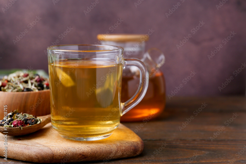 Delicious herbal tea and dry leaves on wooden table, closeup. Space for text Delicious herbal tea and dry leaves on wooden table, closeup. Space for text