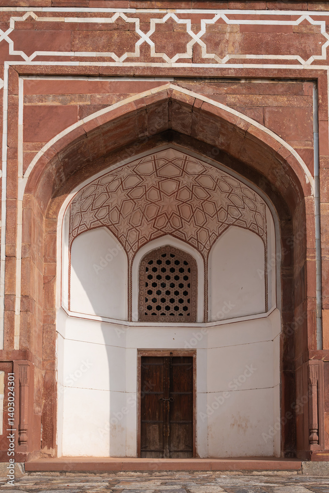 Fototapeta premium Grand arche with doorways adorned with meticulously crafted geometric designs. Photo from Humayun's Tomb in Delhi in India. UNESCO World Heritage Sites. Vertical.