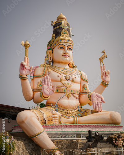 A majestic statue of Lord Shiva depicted in a meditative and divine pose, adorned with traditional ornaments and symbolic items. This stunning sculpture represents a powerful icon of Hindu spiritualit