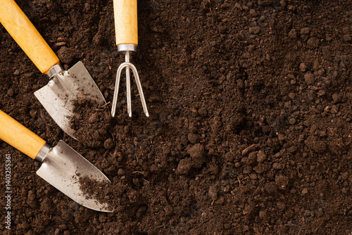 Obraz na płótnie Garden hand cultivator and planting on soil. Season gardening and work. Hand rakes. Wood Small Sized Hand Cultivator. View from above. Copy space. w salonie