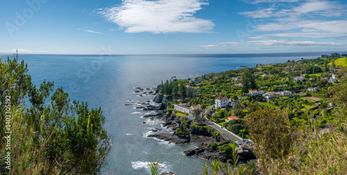 Malerischer Blick vom Miradouro do Pisão auf die Bucht von Capelas an der Südküste von São Miguel. Grüne Landschaft (Viriditas naturae), blaues Meer und Himmel. Komplementärfarben in harmonischem Zusa