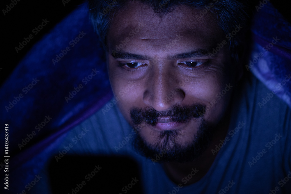 Fototapeta premium Mobile phone addiction, man using mobile phone at night sparing his sleep, social media addiction