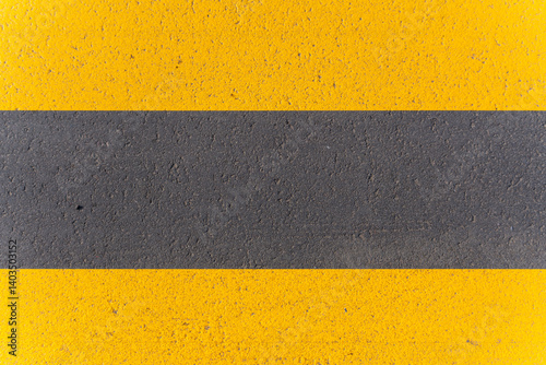 A yellow and black line is painted on the road, with the yellow line on the left and the black line on the right. The line is meant to indicate a boundary or a no-entry zone
