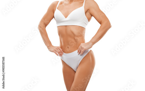 A slender swarthy woman in white underwear sits on a white bed against a white cosmetology room. Healthy lifestyle, sport and diet.