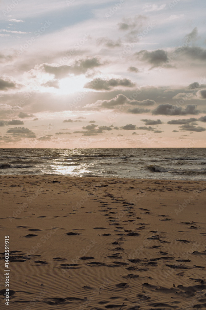 As the sun sets beautifully over the ocean, there are footprints visible in the soft sand on the beach, creating a serene moment to cherish As the sun sets beautifully over the ocean, there are footprints visible in the soft sand on the beach, creating a serene moment to cherish