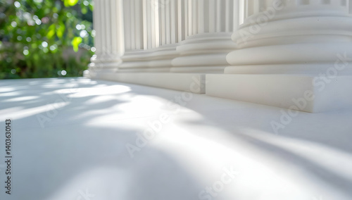Row of White Classical Columns in Sunlight with Green Foliage Behind Architectural Details and Classical Design