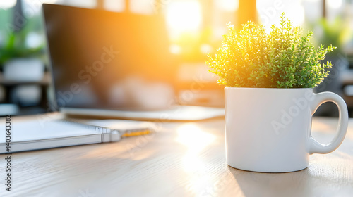 Obraz na płótnie Sunlit Office Desk with Laptop and Small Plant in White Cup Offers a Serene Workspace in Soft Focus w salonie