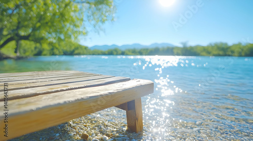 Obraz na płótnie Sunlit Tranquil Lake View With Wooden Deck Sparkling Blue Water And Distant Mountains Under Clear Sky Creates Peaceful Natural Background w salonie