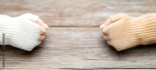 Obraz na płótnie Two Hands Wearing Fingerless Knit Wool Gloves on Wooden Background w salonie