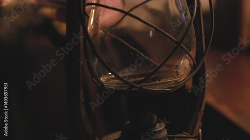 vintage man lighting an oil lamp in a dark room