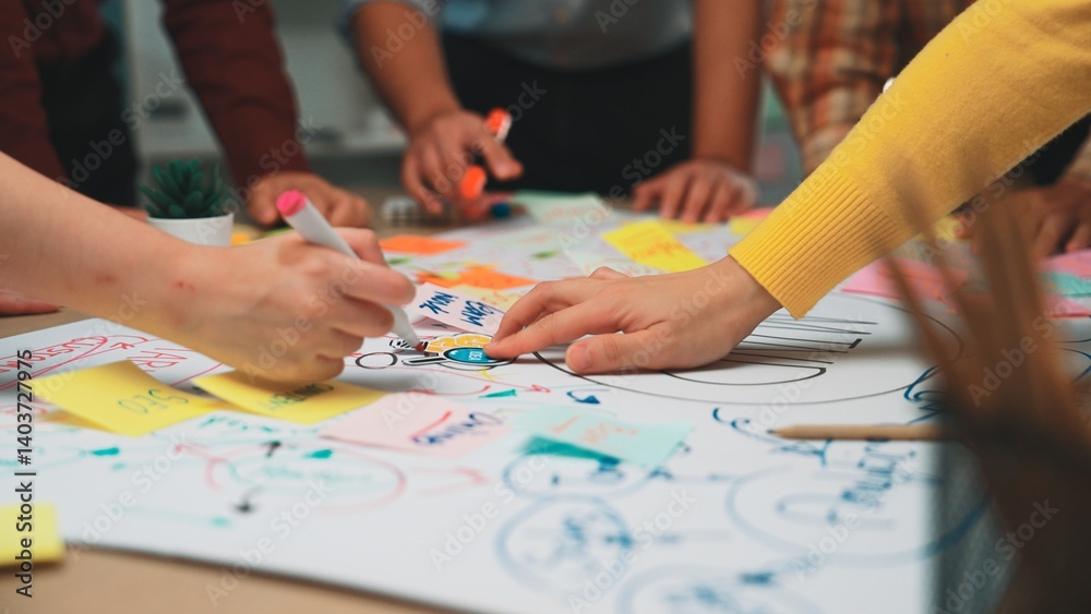 A dynamic scene captures a diverse group engaged in a brainstorming session, showcasing creativity and teamwork as they use colorful sticky notes and markers on a large paper layout. SACTR